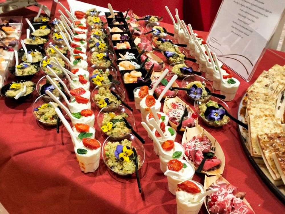 Buffet di finger food gourmet assortiti con presentazioni creative e colorate